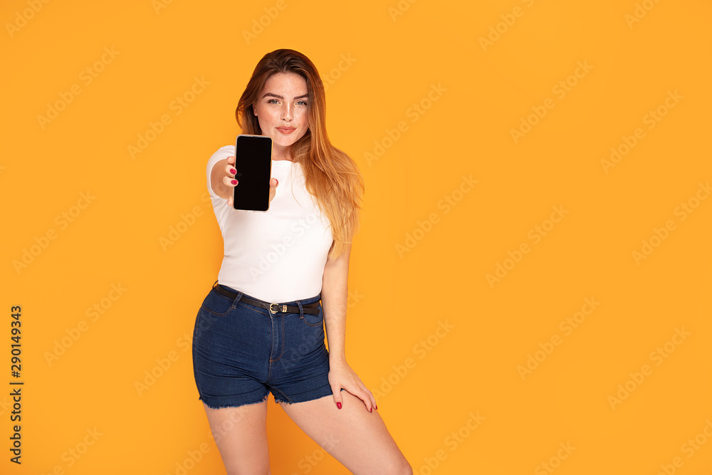Smiling girl showing mobile phone with empty screen. Smiling girl showing mobile phone with empty screen.