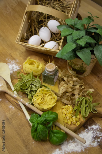 Nudeln auf Brett mit Eiern und Kochlöffeln