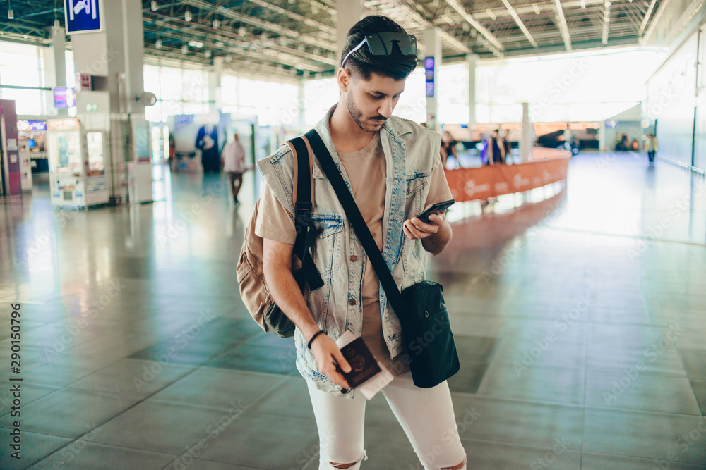 Fototapeta premium Stylish man using cellphone and prepare for trip