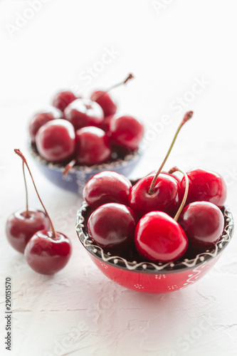 Cherries in ceramic bowls on white background. Fresh ripe red cherry berries.