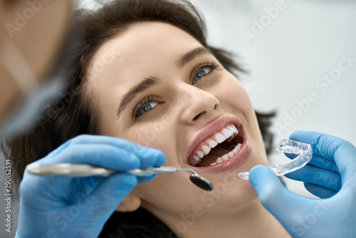 Pretty woman's teeth treatment in dental clinic