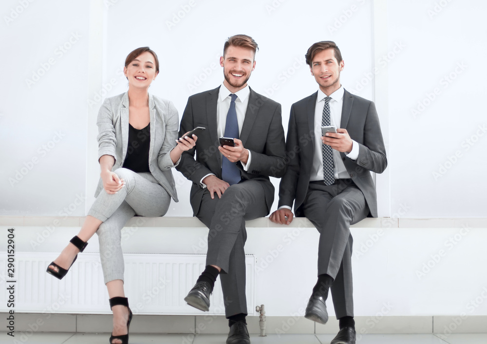 business team sitting in the office hallway on a work break business team sitting in the office hallway on a work break