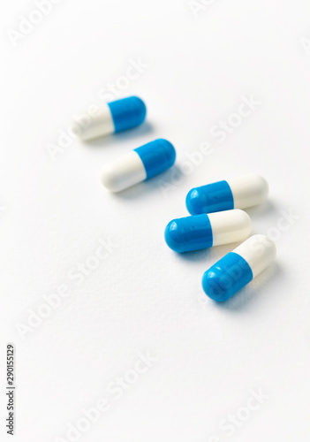 Tri-Creatine capsules. Bodybuilding food supplements on white paper background. Close up. Copy space. 