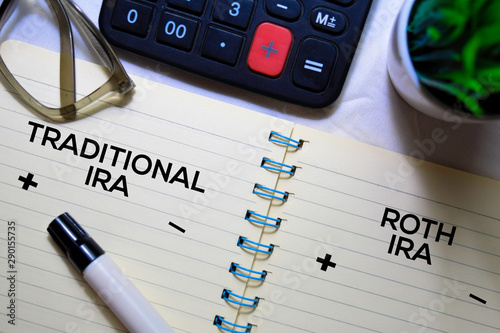 Traditional IRA and Roth IRA text on a book isolated on office desk. photo