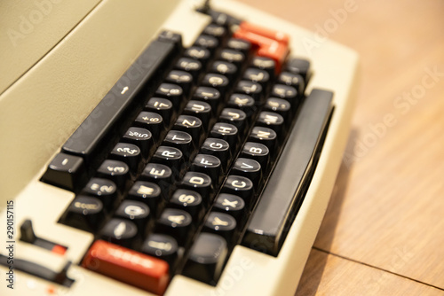 Old typewriter machine with German keyboard layout qwertz and red buttons standing on the table.