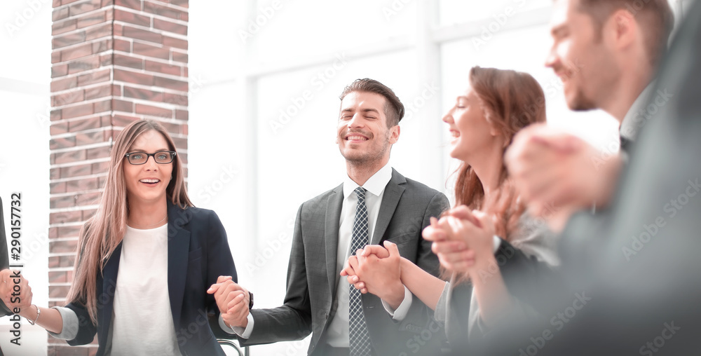 Business group in a circle holding hands indoors Business group in a circle holding hands indoors