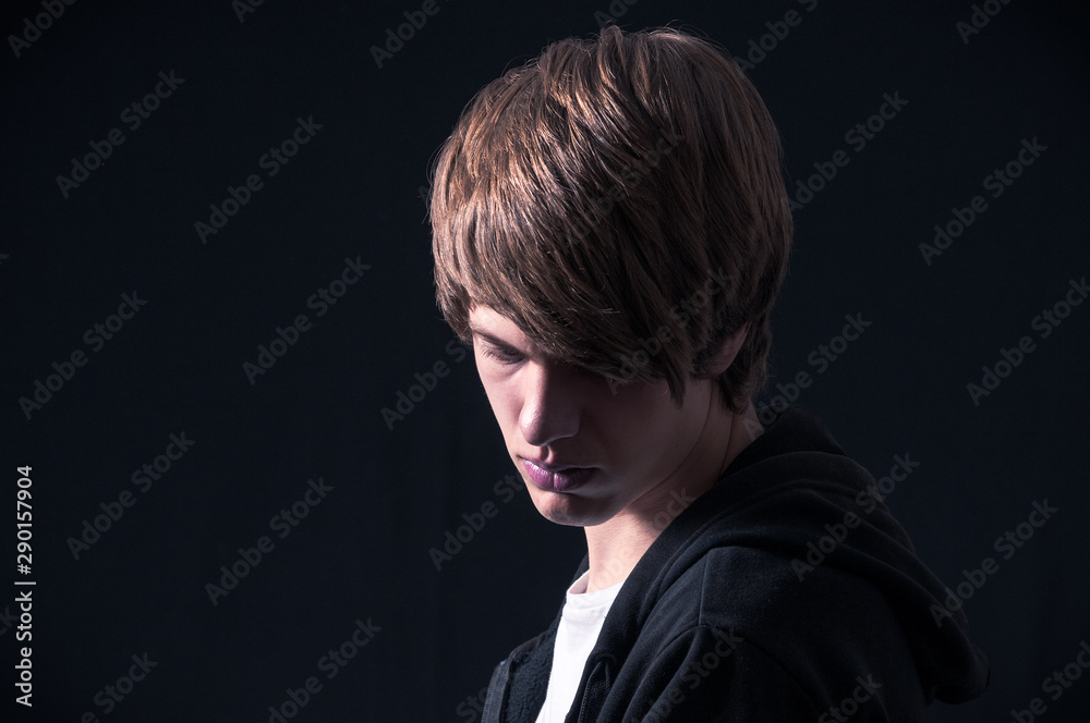 Blond boy with sweatshirt photographed in studio with black background Blond boy with sweatshirt photographed in studio with black background