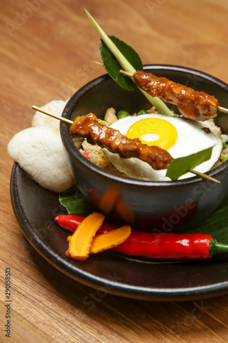 Nasi goreng - fried rice with chicken satay and a fried egg. Exquisite dish. Creative restaurant meal concept.