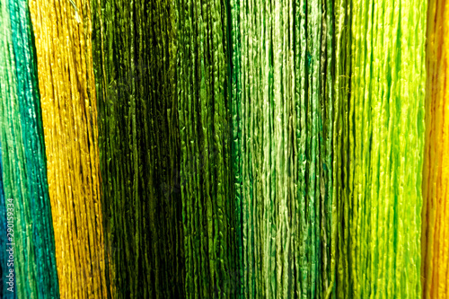 close-up on bast curtain in green and yellow tones as background 
