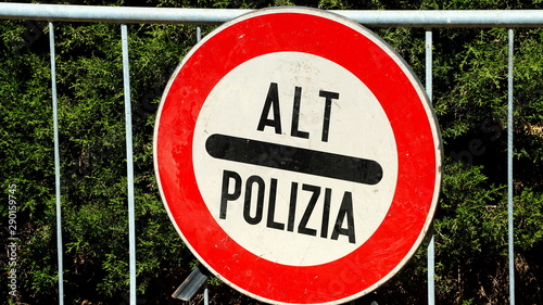 Street traffic sign written in Italian ALT POLIZIA on a metal barrier against the sun. Image for road safety photo