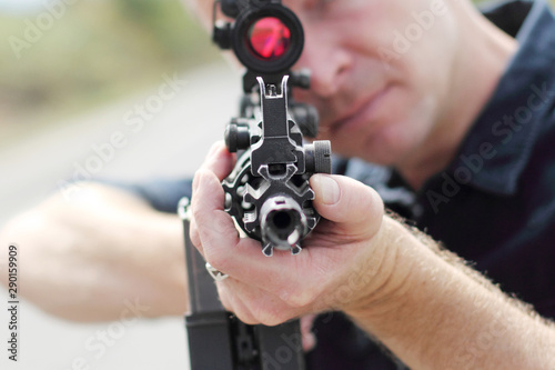 Obraz na płótnie Closeup of a man aiming an assault rifle with scope.