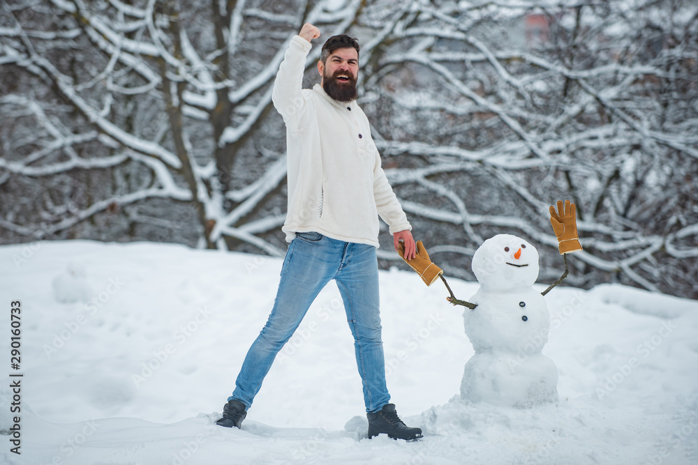 Holly jolly swag Christmas and noel. Happy hipster winter portrait. Snowman. Winter portrait of young handsome hipster in snow Garden make snowman. Holly jolly swag Christmas and noel. Happy hipster winter portrait. Snowman. Winter portrait of young handsome hipster in snow Garden make snowman.