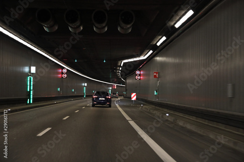 Tunnel with a black car and different signs and lights