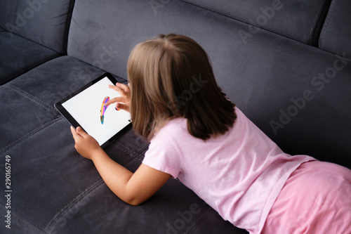 Preschool Girl Draws on the Tablet. Little girl play with tablet