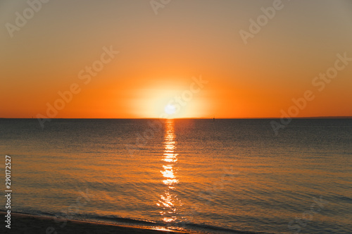 Orange sunset over water near the beach - minimal seascape with copy space