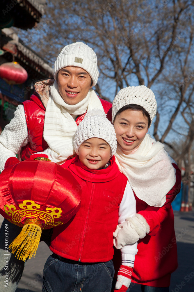 Family holding lantern dressed in holiday attire