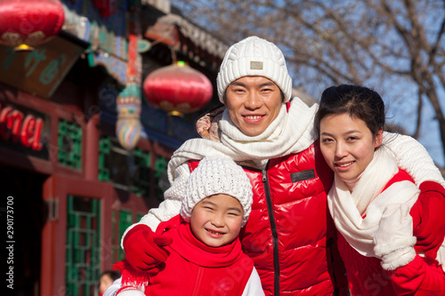 Family holding lantern dressed in holiday attire