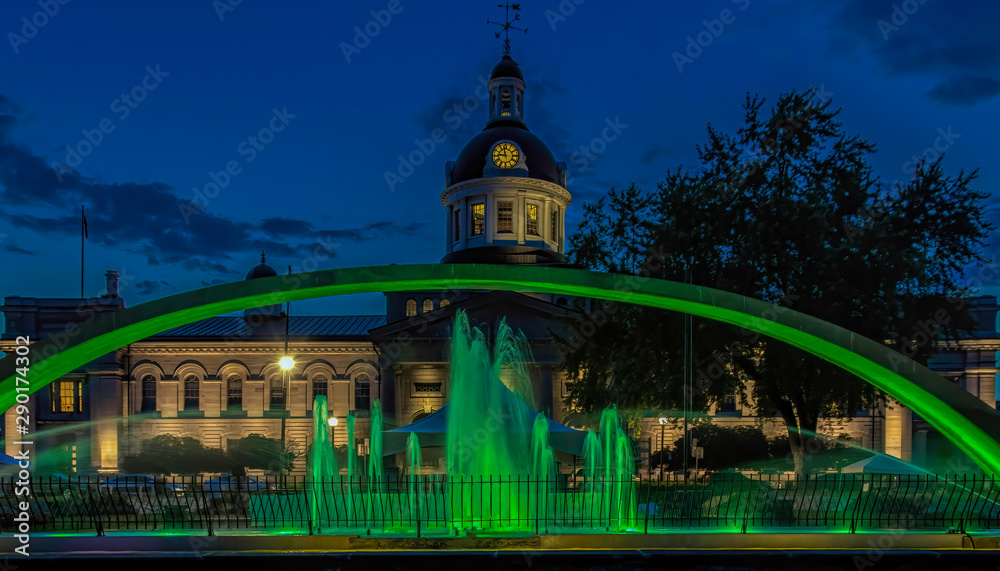 Kingston City Hall at Night seen through green arch and lighted fountains nobody