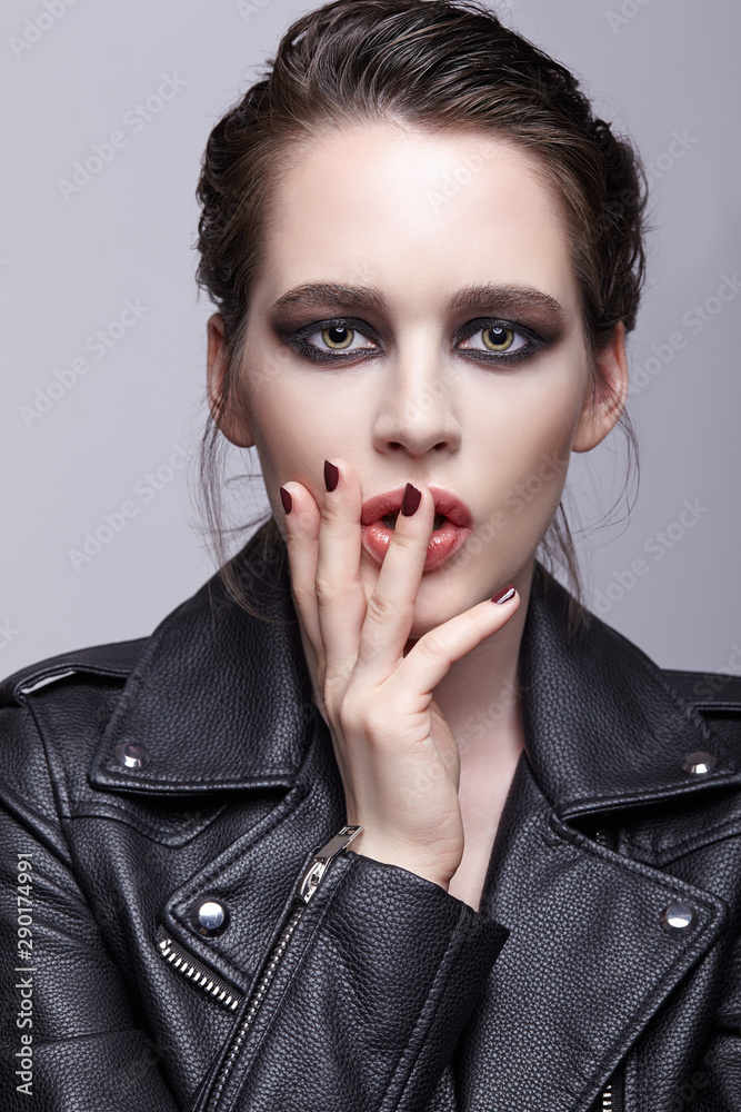 Portrait of female in black leather jacket. Woman with unusual beauty evening makeup and violet - black shadows make-up. Portrait of female in black leather jacket. Woman with unusual beauty evening makeup and violet - black shadows make-up.