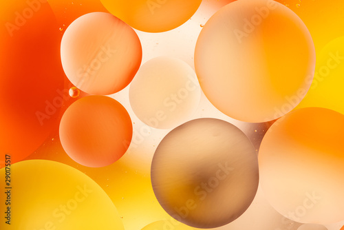 bright oily drops in water with colorful background, close-up 