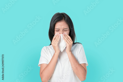 Young Asian woman use paper napkin the mouth and nose because allergy. on the blue background.