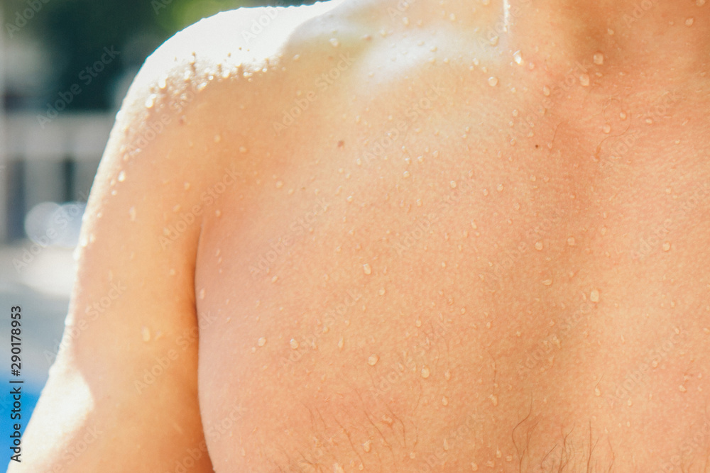 Fototapeta premium wet man. Drops trickle down my back. Happy man after hard physical work. the concept of strength exercises, weight loss, tanning, swimming