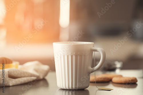 Cup with delicious tea on table
