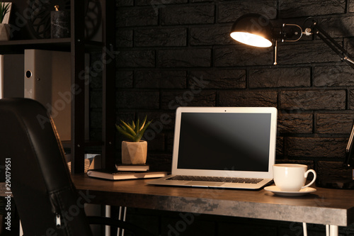Stylish workplace with modern computer near dark brick wall at home © Pixel-Shot