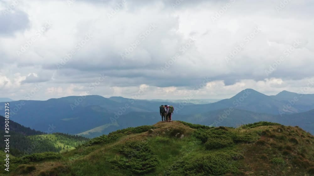 The four hikers standing on the beautiful mountain The four hikers standing on the beautiful mountain