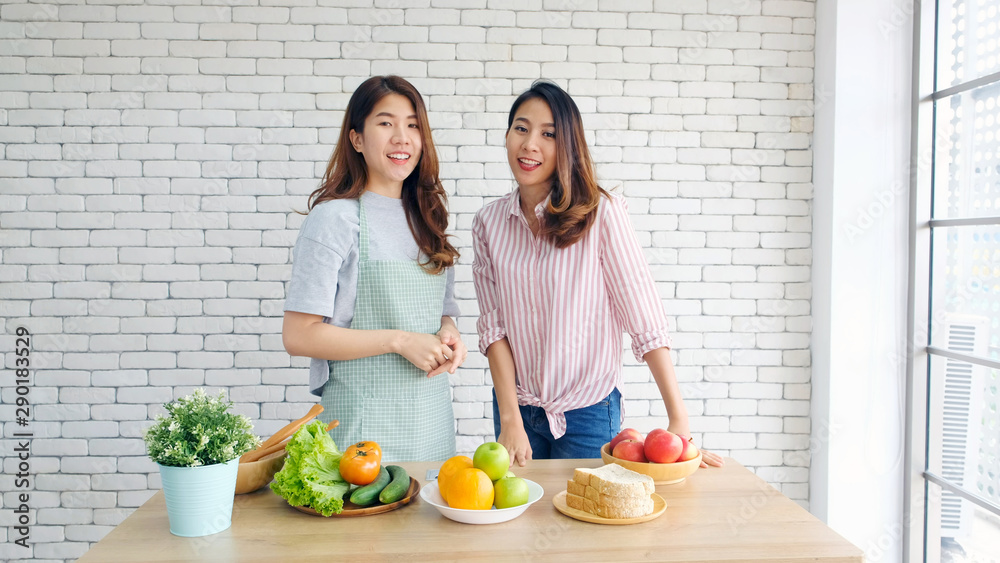 Two young asian women healthy food bloggers look at camera while recording video with happy moment, vlog concept, people and technology communication Two young asian women healthy food bloggers look at camera while recording video with happy moment, vlog concept, people and technology communication