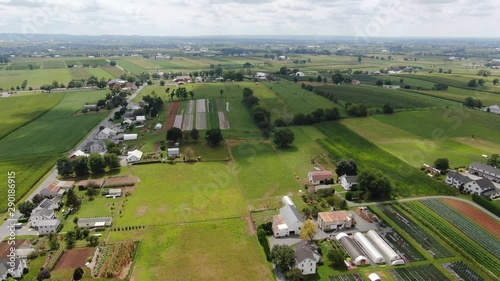 Descending aerial shot of typical Pennsylvania farmland, shadows of clouds moving quickly, roadside produce stand photo