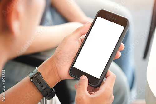 Cropped shot view of man hands holding smart phone with blank copy space screen for your text message or information content, female reading text message on cell telephone during in urban setting. 