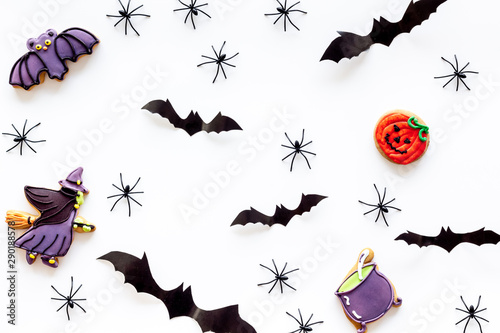 Cute Halloween decoration. Bats  spiders and special cookies on white background top view pattern