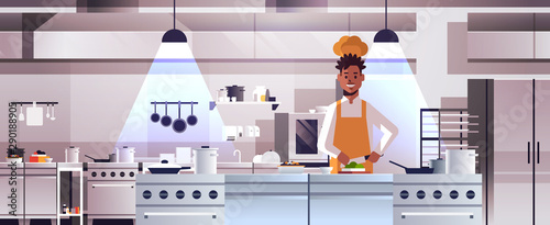 male professional chef cook chopping vegetables on carving board african american man in uniform preparing salad cooking food concept modern restaurant kitchen interior portrait horizontal