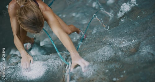 Young fit woman rock climbing outdoors, rock climber reaching for hold and falling, slow motion rock climbing