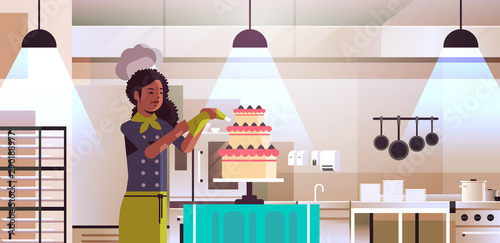 female professional chef pastry cook decorating tasty wedding cream cake african american woman in uniform cooking food concept modern restaurant kitchen interior flat portrait horizontal