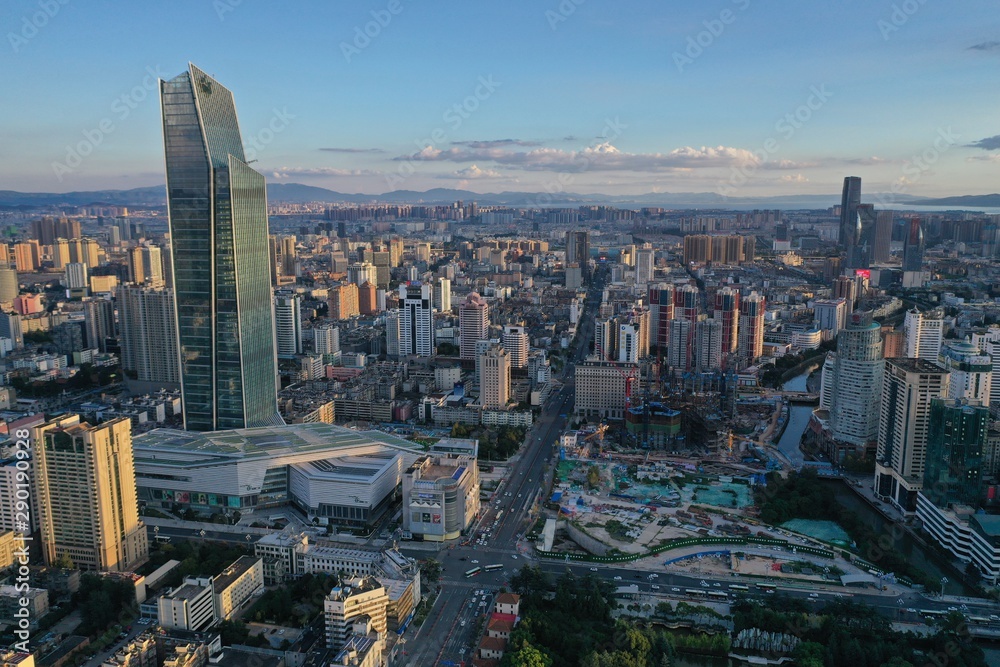 Kunming, China - September 13, 2019: Aerial view of Kunming at sunset with the Spring City 66 skyscraper and mall on foreground