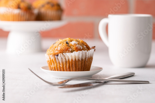 Blueberry muffins with white table place setting.
