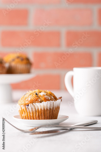 Blueberry muffins with white table place setting.