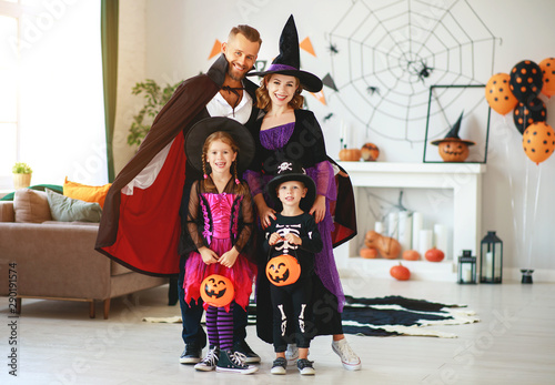 happy family mother father and children in costumes on Halloween.