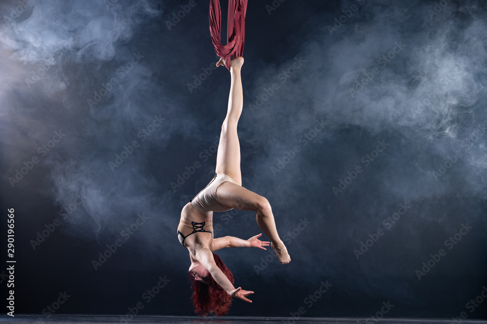 Fototapeta Kobieta atletyczna, seksowna i elastyczna powietrzna artystka cyrkowa z rudą tańczącą w powietrzu na jedwabiu
