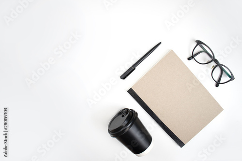 Top view, notebook, pen, eye glasses And coffee on a white background isolated background. Modern business concept.