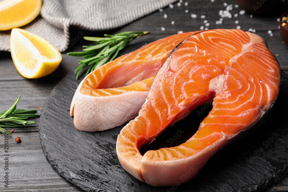 Fresh salmon steaks on black wooden table Fresh salmon steaks on black wooden table