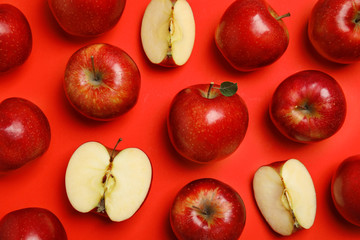 Flat lay composition with ripe juicy apples on red background