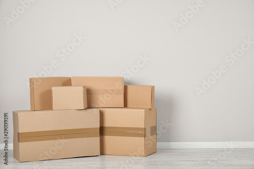 Pile of cardboard boxes near light wall indoors. Space for text © New Africa