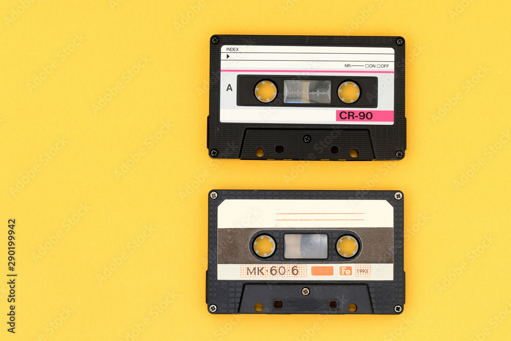 Fototapeta premium Old audio tape cassettes on a bright yellow background. Top view, old technology concept