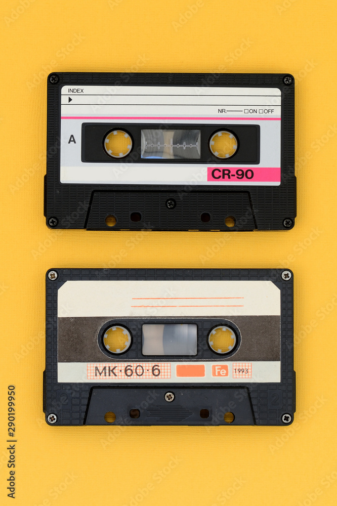 Old audio tape cassettes on a bright yellow background. Top view, old technology concept