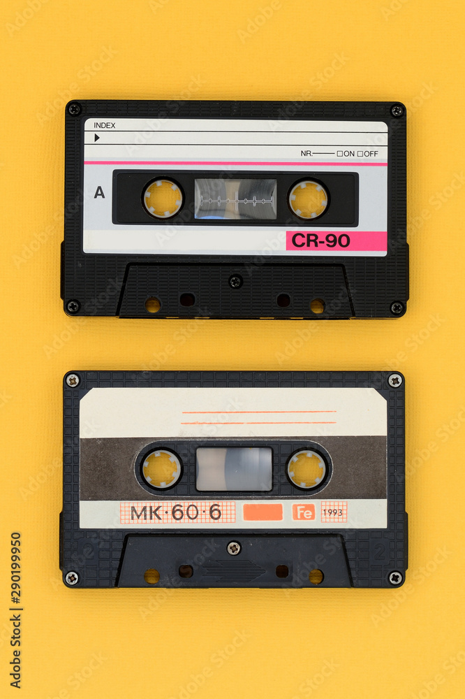 Fototapeta premium Old audio tape cassettes on a bright yellow background. Top view, old technology concept