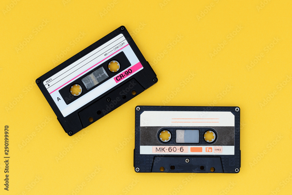Fototapeta premium Old audio tape cassettes on a bright yellow background. Top view, old technology concept