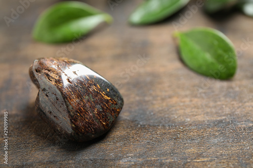 Beautiful brown bronzite gemstone on wooden table photo